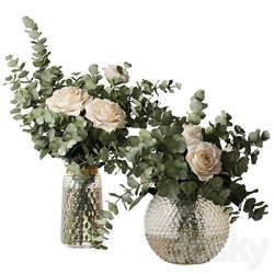 Two bouquets of roses and eucalyptus branches in glass mottled vases 